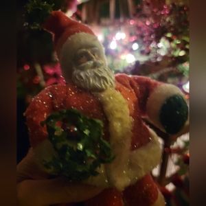 Decorative Santa decor Christmas . He GLISTENS and is propped up against the tre